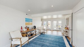 A modern kitchen with a blue rug, white furniture, and a view through glass doors. - Keen-Wik on the Bay bay front home w/private pool & hot tub (Selbyville)