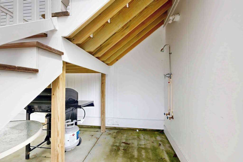 Una habitación con techo inclinado, una parrilla empotrada y un calentador de agua.