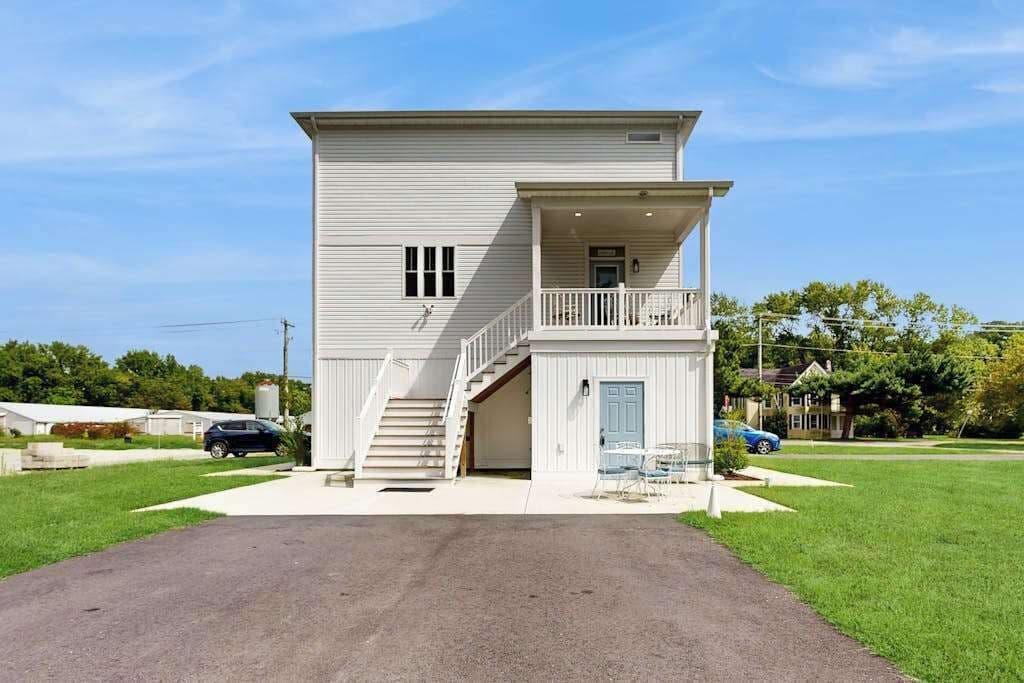 Uma casa de dois andares com varanda frontal, escada que leva ao segundo andar e garagem.