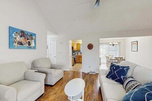 A living room with two sofas, a coffee table, and a painting on the wall. - Breezewood dog-friendly house w/firepit, deck, patio, grill & game room (Rehoboth Beach)
