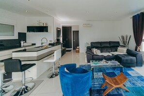 Una sala moderna con un sofá, una mesa de centro y una silla azul.