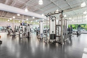 A gym with various exercise machines, a large mirror, and a ceiling with industrial lighting. - Sea Colony - 39469 Woodland View #5303 | Condo in Bethany Beach (Bethany Beach)