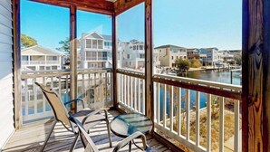 Un balcone coperto con vista su un porto turistico e altri edifici.