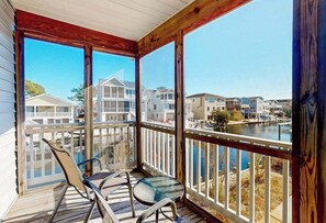 A covered balcony with a view of a marina and other buildings. - Town of South Bethany enchanting canal-front retreat with decks & amazing views (Bethany Beach)