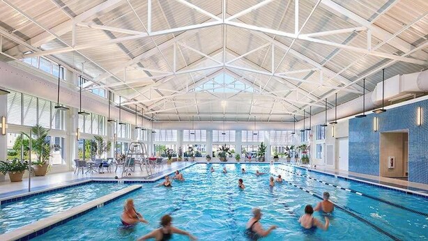 An indoor swimming pool with multiple lanes, large windows, and a high ceiling with a geometric design. - Dazzling Bayside Resort home with pools, gym, & athletic court - close to beach (Selbyville)
