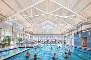 An indoor swimming pool with multiple lanes, large windows, and a high ceiling with a geometric design. - Dazzling Bayside Resort home with pools, gym, & athletic court - close to beach (Selbyville)