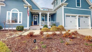 A two-story house with a front porch, a garage, and a well-maintained lawn. - Dazzling Bayside Resort home with pools, gym, & athletic court - close to beach (Selbyville)