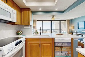 A modern kitchen with wooden cabinets, a microwave, an oven, and a large island with a sink. - Sea Colony Ocean beachfront condo with 12 pools, sauna, tennis, private beach (Bethany Beach)