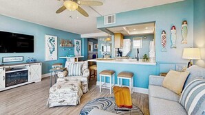 A living room with a sofa, ottoman, and a ceiling fan. - Sea Colony Ocean beachfront condo with 12 pools, sauna, tennis, private beach (Bethany Beach)