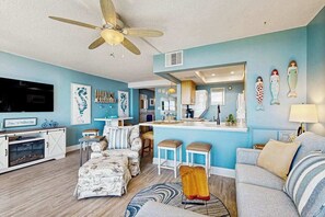 A living room with a sofa, ottoman, and a ceiling fan. - Sea Colony Ocean beachfront condo with 12 pools, sauna, tennis, private beach (Bethany Beach)