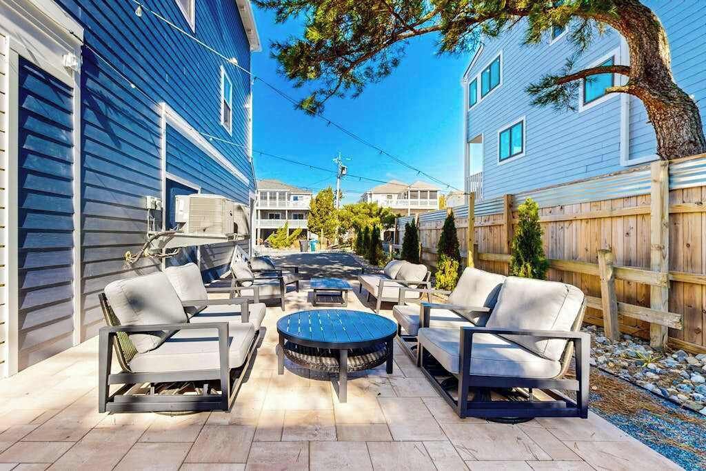 A patio with outdoor furniture, a round table, and a view of neighboring houses.