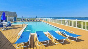A pool area with lounge chairs and a pool on a deck. - Kings Grant Beachfront Townhouse w/Ocean Views, Shared Pool, Free WiFi, Private (Fenwick Island)