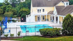 Ett stort hus med en swimmingpool, en täckt uteplats och en inhägnad trädgård.