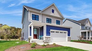A two-story house with a garage, a covered porch, and a well-maintained lawn. - Stingray Harbor condo with W/D, WIFI, close to restaurants (Ocean View)