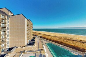 Ein Hochhaus mit mehreren Balkonen mit Blick auf Strand und Meer.
