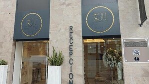 A reception area with a sign reading 'RECEPTION' and two doors with circular logos. - Deluxe Compact Flat With Jacuzzi (Alicante)
