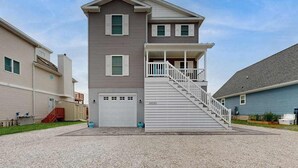 A two-story building with a central staircase, a garage, and a small porch. - Spacious home w/community boat launch, dock, patio, W/D, & AC (Selbyville)