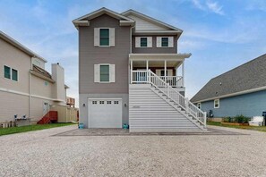 A two-story building with a central staircase, a garage, and a small porch. - Spacious home w/community boat launch, dock, patio, W/D, & AC (Selbyville)
