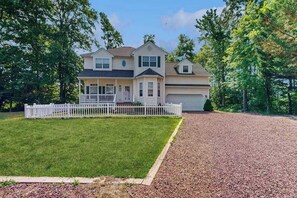 A two-story house with a front porch, a garage, and a well-maintained lawn. - Clearwater Home Close to the Beach w/Shared Pool, Private Washer/Dryer (Frankford)