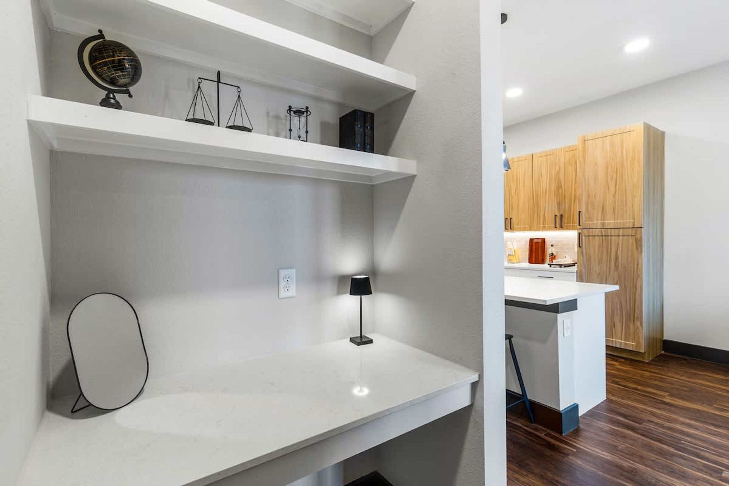 A modern kitchen with wooden cabinets, a white countertop, and a small island.