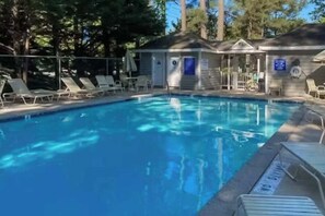 A swimming pool with lounge chairs and a small building with a door and windows. - Westwood townhouse w/community pool, tennis court, bike to beach (Bethany Beach)