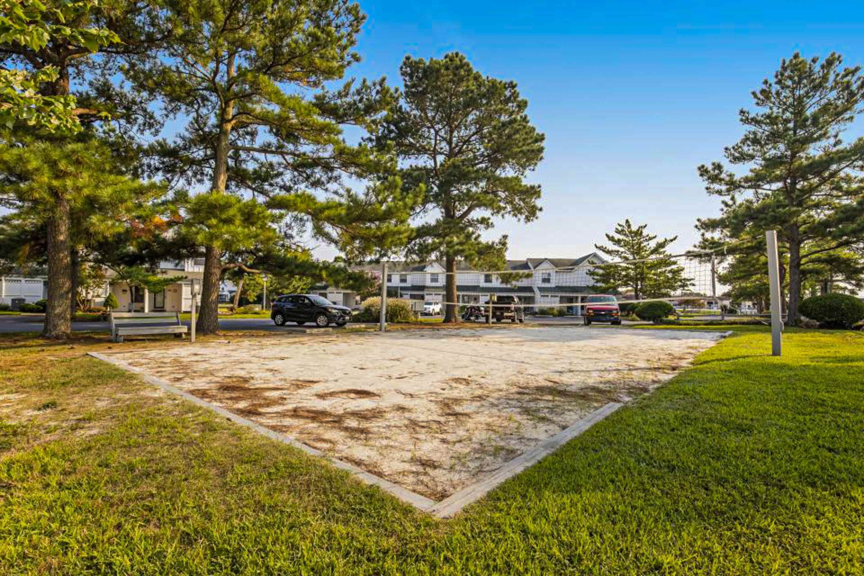 Un quartiere residenziale con un'ampia area aperta, forse un parco o un cortile, circondato da case e alberi.