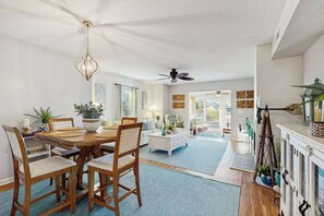 A spacious living area with a dining table, chairs, a sofa, and a fireplace.