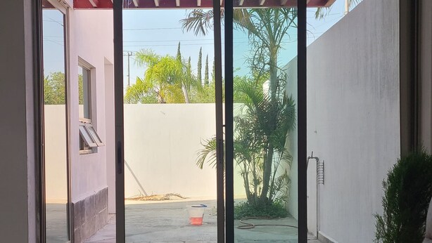 A modern interior with a sliding glass door leading to an outdoor patio area. - Casa Mariachi & World Cup (Las Víboras)
