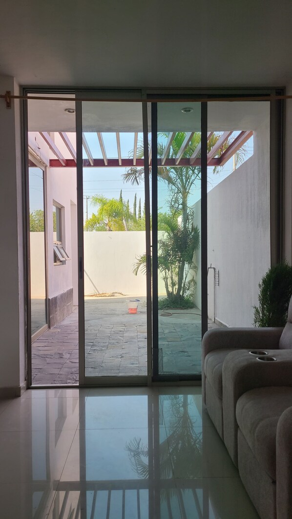 A modern interior with a sliding glass door leading to an outdoor patio area.