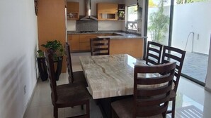 A modern kitchen with a dining area, large windows, and a view of the outdoors. - Casa Mariachi & World Cup (Las Víboras)