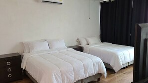A hotel room with two beds, a dark wooden nightstand, a white wall, and a black curtain. - Casa Mariachi & World Cup (Las Víboras)
