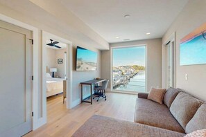 Ein modernes Hotelzimmer mit Bett, Schreibtisch und großem Fenster mit Blick auf die Stadt.