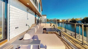 Terraza con mobiliario exterior, piscina y vista al agua.
