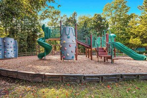 Ein Spielplatz mit Klettergerüsten, Rutschen und einer Holzeinfassung.