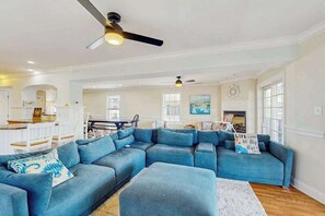 Ein geräumiges Wohnzimmer mit einer Eckcouch, einem Essbereich und einer Küche im Hintergrund.
