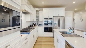 A modern kitchen with white cabinetry, stainless steel appliances, and a central island. - Milo's Haven townhouse w/community pool, grill, close to restaurants (Frankford)
