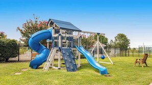 Ein Spielplatz mit einer blauen Rutsche und Kletterbereich.