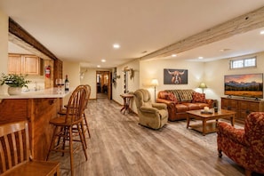 A spacious living area with a kitchen, a dining area, a fireplace, and a television. - Harbour Hideout | Downtown Sheridan WY Basement Stay | 3 King Beds | Sleeps 8 | Steps to Blacktooth Brewing | Free BJJ Class | Full Kitchen | Fast WiFi (Sheridan)