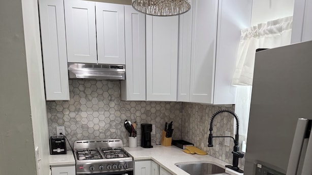 A kitchen with white cabinets, a stainless steel stove, a dishwasher, and a refrigerator. - Charming 1-bedroom apartment with AC in lively Philadelphia / a beautiful view. (Philadelphia)