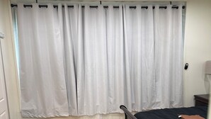 A bedroom with a wooden floor, a bed with a dark headboard, a ceiling fan, and white curtains. - Charming 1-bedroom apartment with AC in lively Philadelphia / a beautiful view. (Philadelphia)
