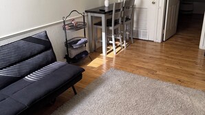 A room with a sofa, a small table with chairs, a white door, and a hallway. - Charming 1-bedroom apartment with AC in lively Philadelphia / a beautiful view. (Philadelphia)