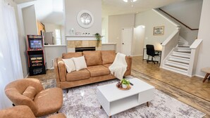 Ein Wohnzimmer mit braunem Sofa, weißem Couchtisch und einem Kamin.