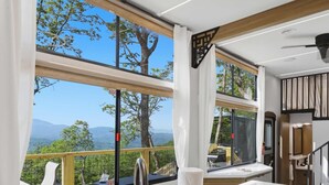 A modern kitchen with a large window, a sink, and a stove. - The Pine- Smoky Mountains View Tiny House w/ Hot Tub & Deck (Tallassee)