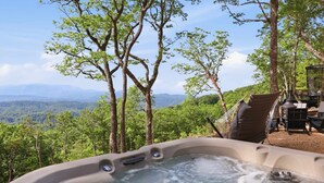 A hot tub surrounded by trees with a view of a mountainous landscape. - The Pine- Smoky Mountains View Tiny House w/ Hot Tub & Deck (Tallassee)