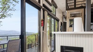 Ein modernes Interieur mit Kamin, großen Fenstern und Blick ins Freie.