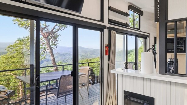 Eine moderne Küche mit einer großen Kochinsel, einem Kamin und Blick ins Freie.