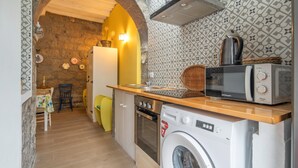 Una cocina compacta con lavadora, microondas y horno.