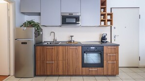 Een moderne keuken met een ingebouwde oven, magnetron en een roestvrijstalen koelkast.