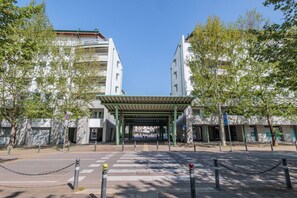A building entrance with a covered walkway, trees, and a clear sky. - Comfortable 50m2 apartment, ideal for 2 people, located on the third floor of a building with a lift.The accommodation is located in a strategic position less than 1.5 km from the center of Bergamo and the train station, easily reachable both on foot and (Bergamo)