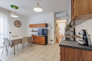 A modern kitchen with a dining area, wooden cabinets, a built-in oven, and a coffee machine. - Comfortable 50m2 apartment, ideal for 2 people, located on the third floor of a building with a lift.The accommodation is located in a strategic position less than 1.5 km from the center of Bergamo and the train station, easily reachable both on foot and (Bergamo)